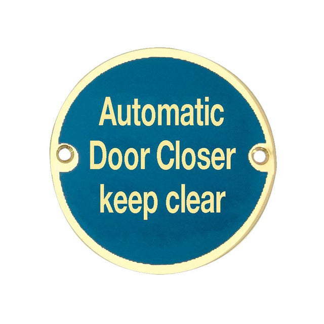 This is an image showing the Frelan - Automatic Door Closer Keep Clear - Signage 75mm Dia. - Polished Brass available to order from T.H. Wiggans Ironmongery in Kendal